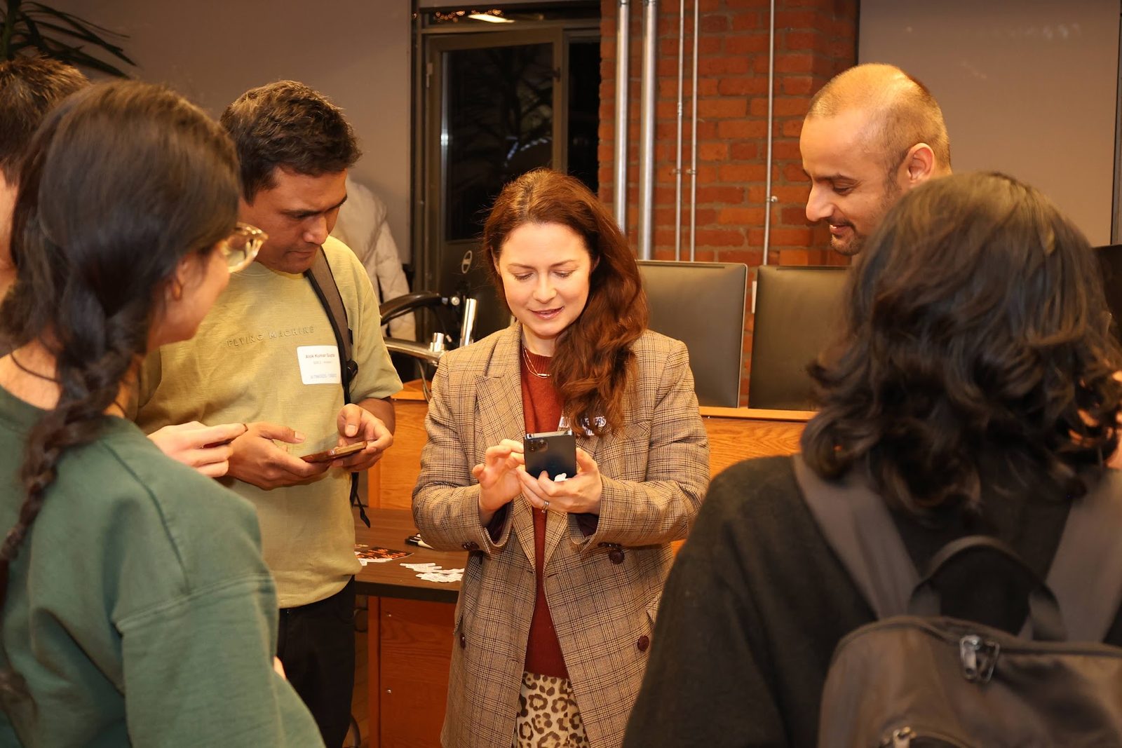 A small group gathered around a phone, working through something together